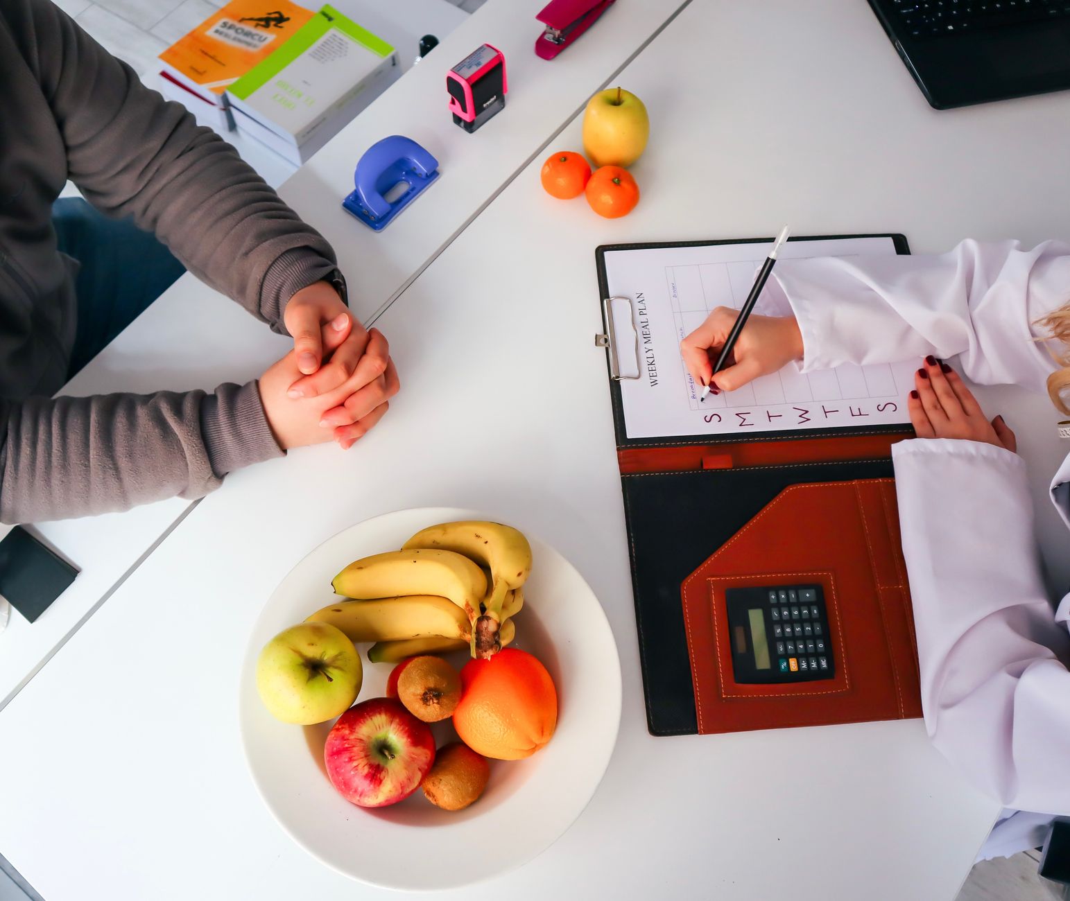 Top view of a dietitian planning a healthy diet with fresh fruits on the table, focusing on health and nutrition. — Find Reli