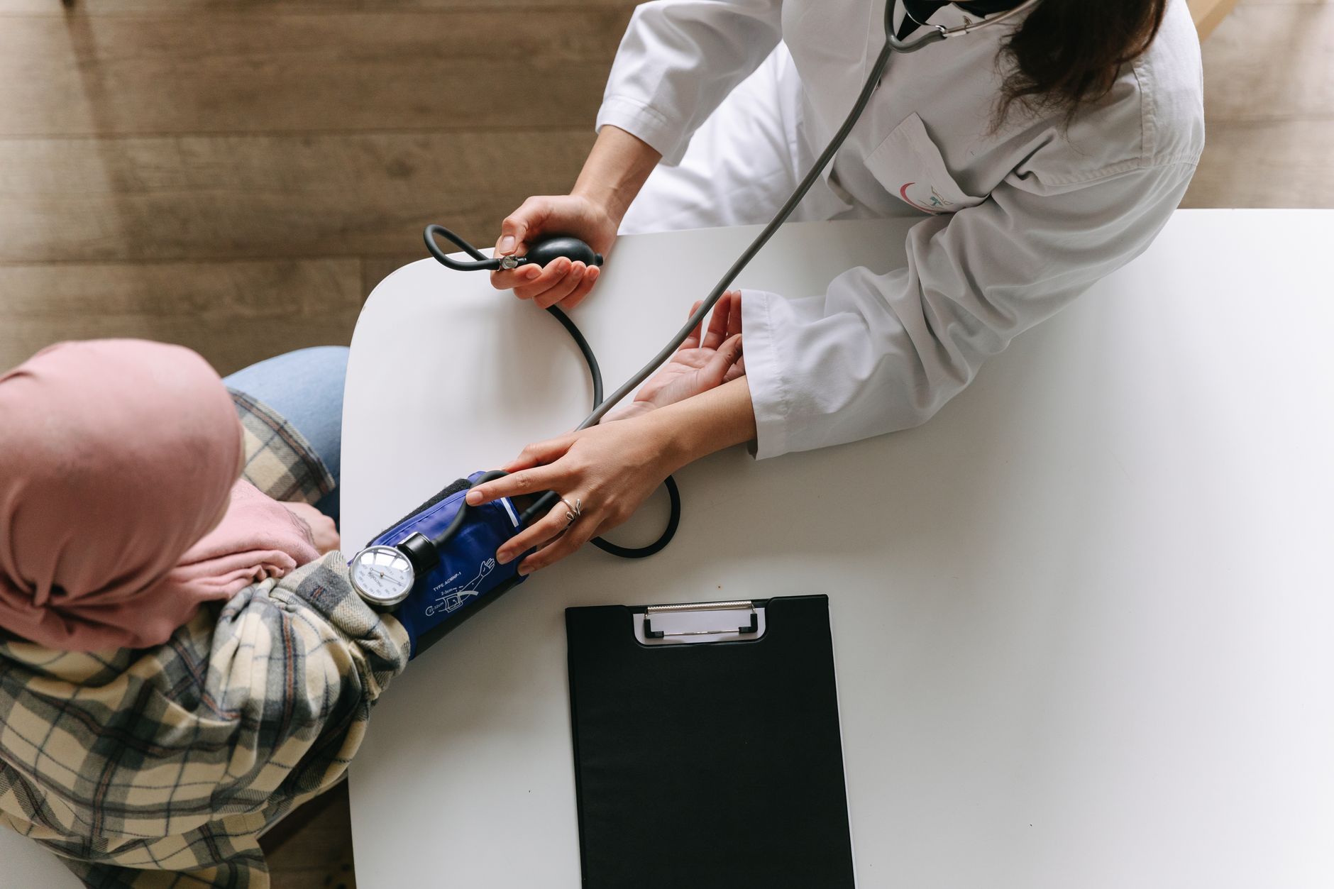 A medical practitioner checks a patient's blood pressure in a clinical setting, showcasing healthcare service. — Pediatric Nu