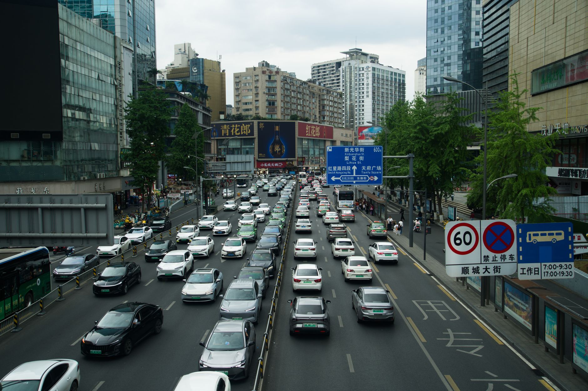 Heavy traffic on a busy Shanghai street lined with skyscrapers and billboards during the day. — Pharmaqo Labs Overview: Compa