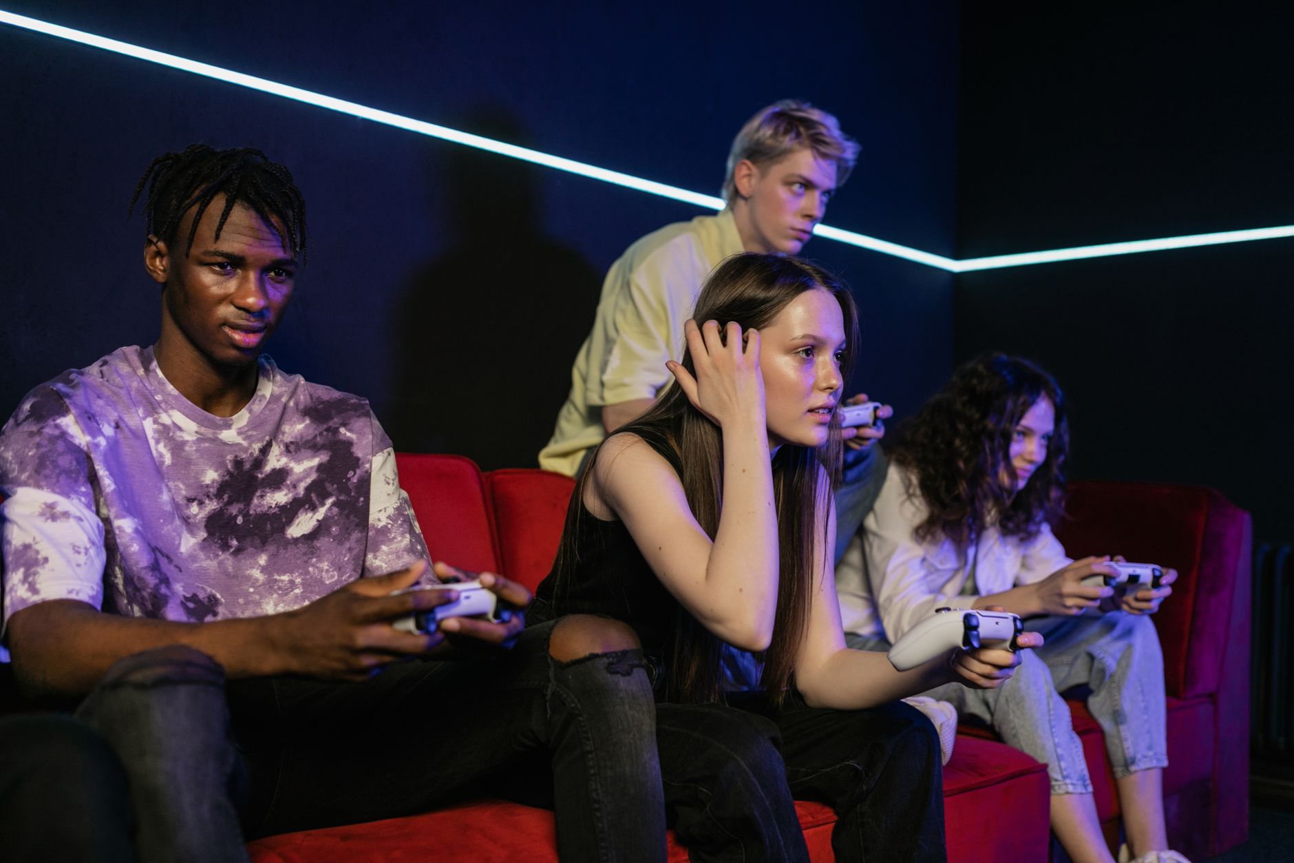 Group of friends enjoying a gaming session on a red sofa with wireless controllers. — What technology makes minesweeper crypt